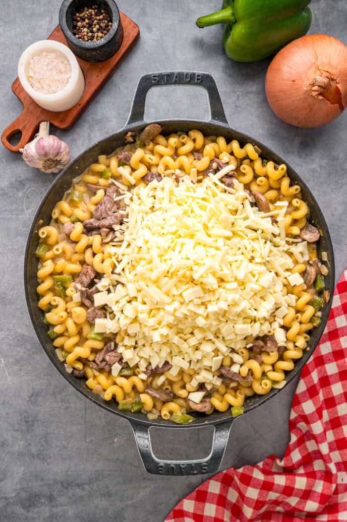 Loaded with sliced ribeye, peppers, onions, mushrooms, and lots of cheese, this Philly Cheesesteak Pasta is an easy one-pan dinner. Sliced ribeye and cheese added to cooked pasta