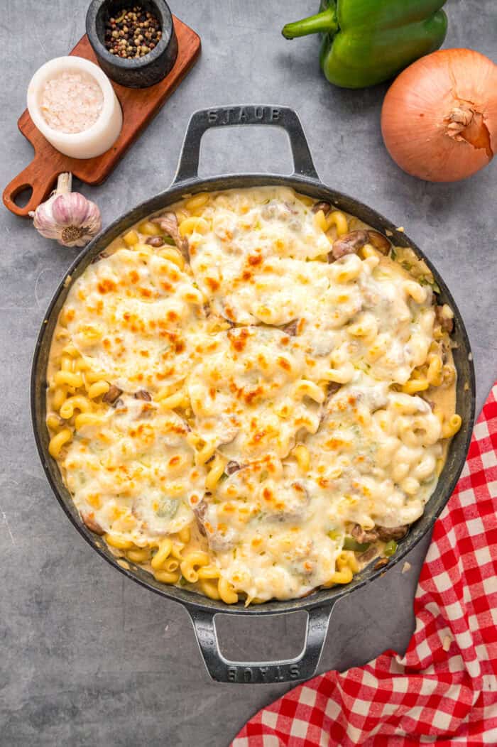 Loaded with sliced ribeye, peppers, onions, mushrooms, and lots of cheese, this Philly Cheesesteak Pasta is an easy one-pan dinner. Overhead view of Philly cheesesteak pasta in the skillet