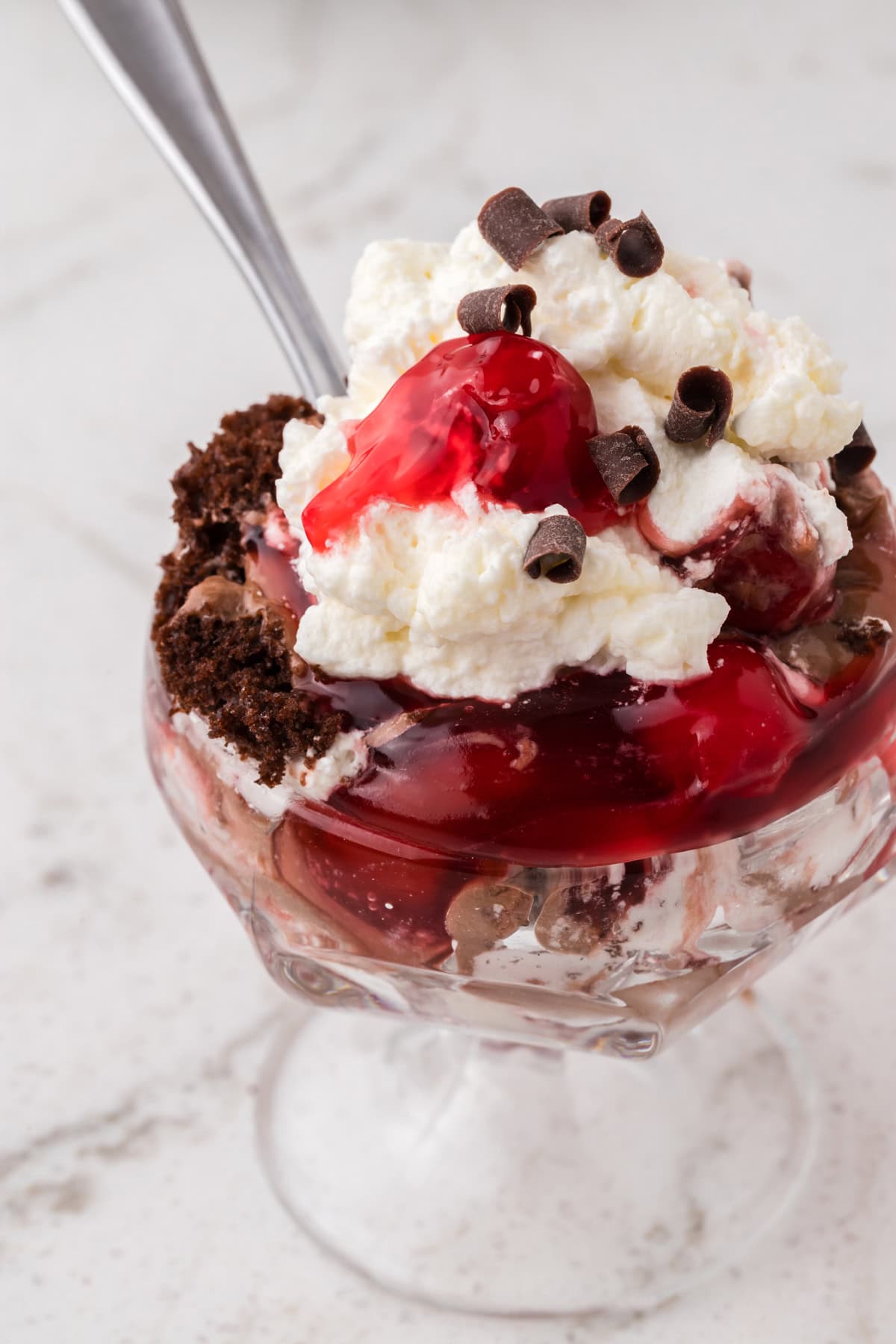 Rich devil’s food cake, cherry pie filling, and homemade whipped cream are layered to make this impressive yet easy Black Forest Trifle. A serving dish of black forest trifle