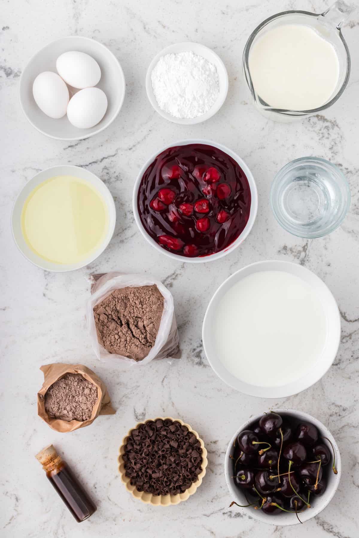 Rich devil’s food cake, cherry pie filling, and homemade whipped cream are layered to make this impressive yet easy Black Forest Trifle. Overhead view of all the ingredients needed to make black forest trifle