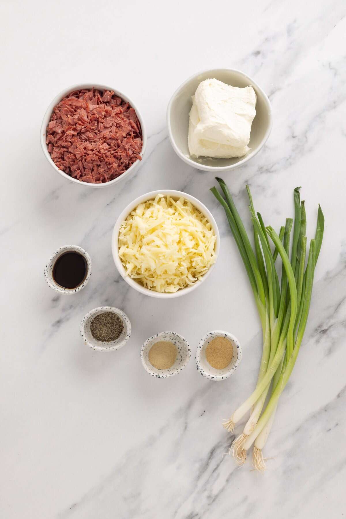 Salty dried beef combines with tangy cream cheese and sharp cheddar cheese to make this irresistible Chipped Beef Cheese Ball. Overhead view of ingredients needed to make chipped beef cheese ball