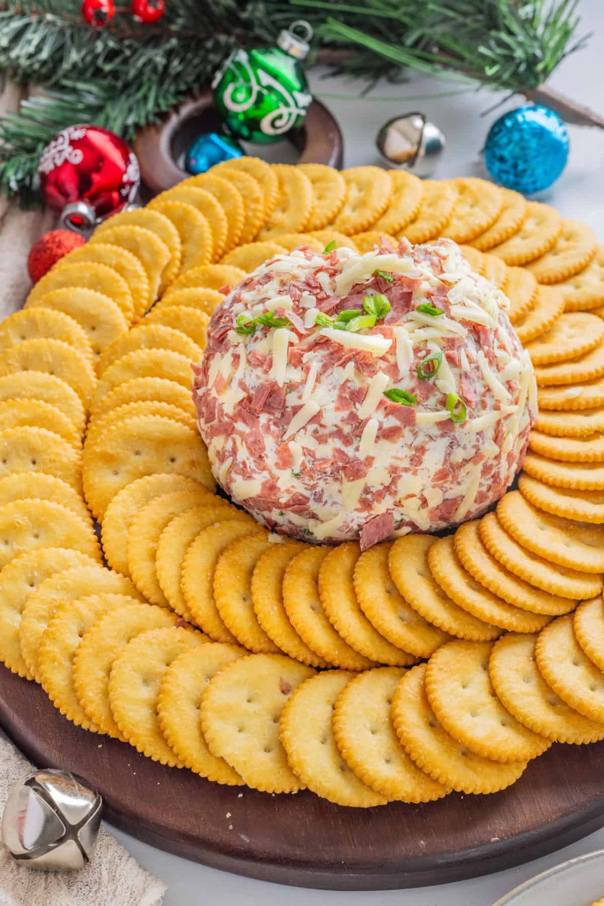 Salty dried beef combines with tangy cream cheese and sharp cheddar cheese to make this irresistible Chipped Beef Cheese Ball. Overhead view of a dried beef cheese ball surrounded by crackers