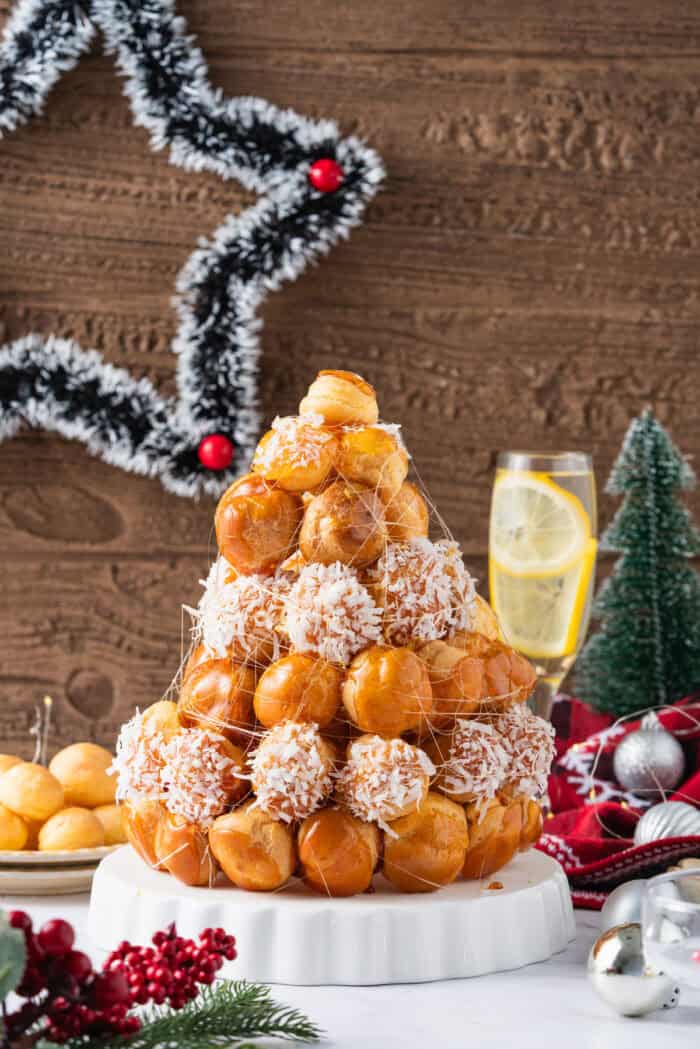 This festive Croquembouche features a stunning tower of cream puffs dipped in glossy amber caramel and sprinkled with shredded coconut. Croquembouche on a plate