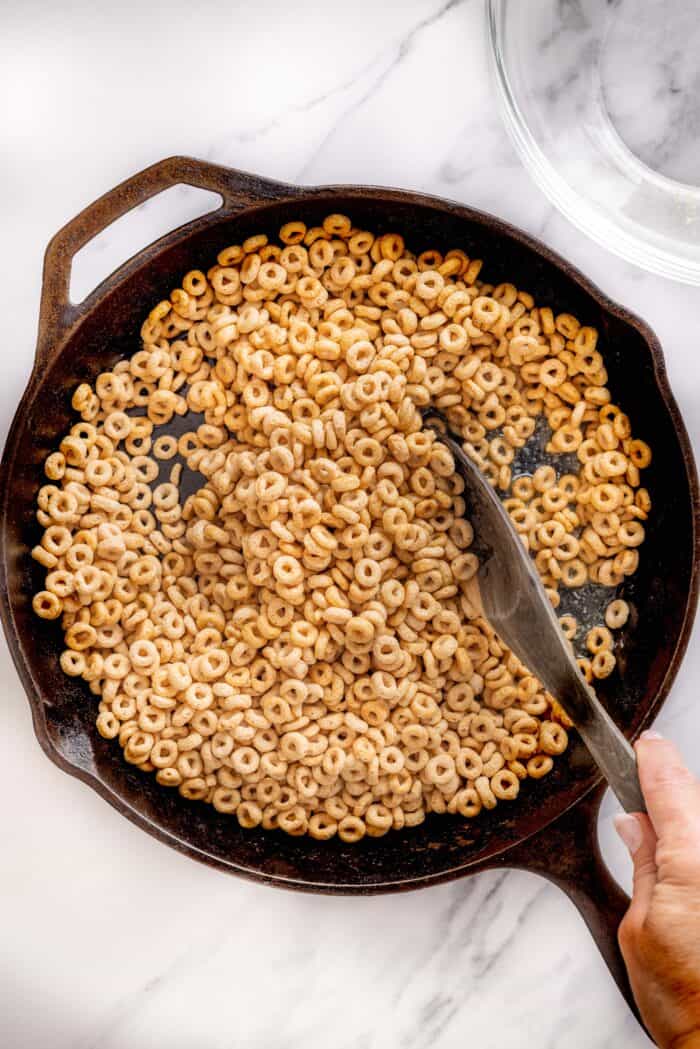 Hot Buttered Cheerios, aka Fried Cheerios, are a nostalgic snack featuring Cheerios toasted in butter and tossed with cinnamon sugar. Stirring Cheerios in melted butter