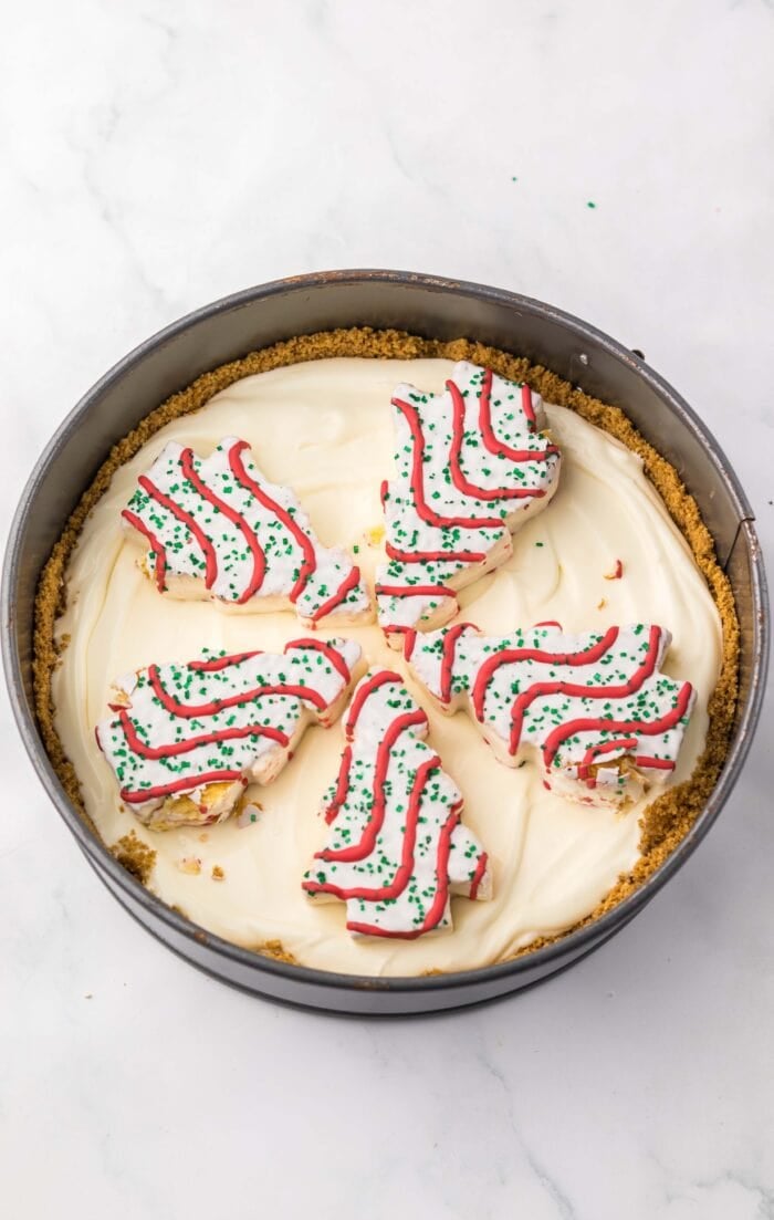 With no baking required, this Little Debbie Christmas Tree Cheesecake is a fun, festive, and nostalgic Christmas treat. Little Debbie Christmas trees on cheesecake filling