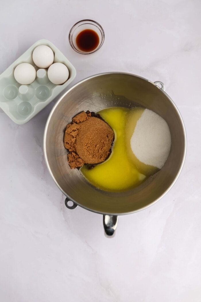 Craving cookies but short on time? These M&M Cookie Bars are like baking a batch of thick, chewy cookies in one pan with 10 minutes of prep. Melted butter, sugar, and brown sugar in a mixing bowl