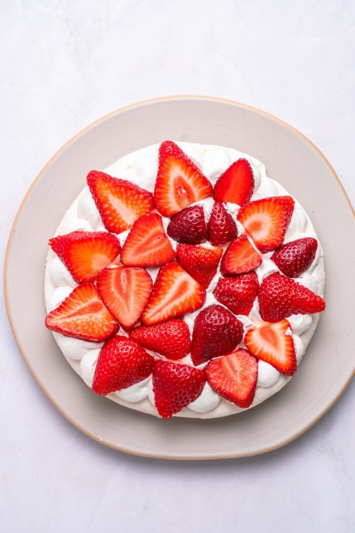 This Strawberry Meringue Cake is light, crisp, and creamy all at once with layers of meringue, fresh strawberries, and whipped cream. Strawberries on top of a layer of whipped cream