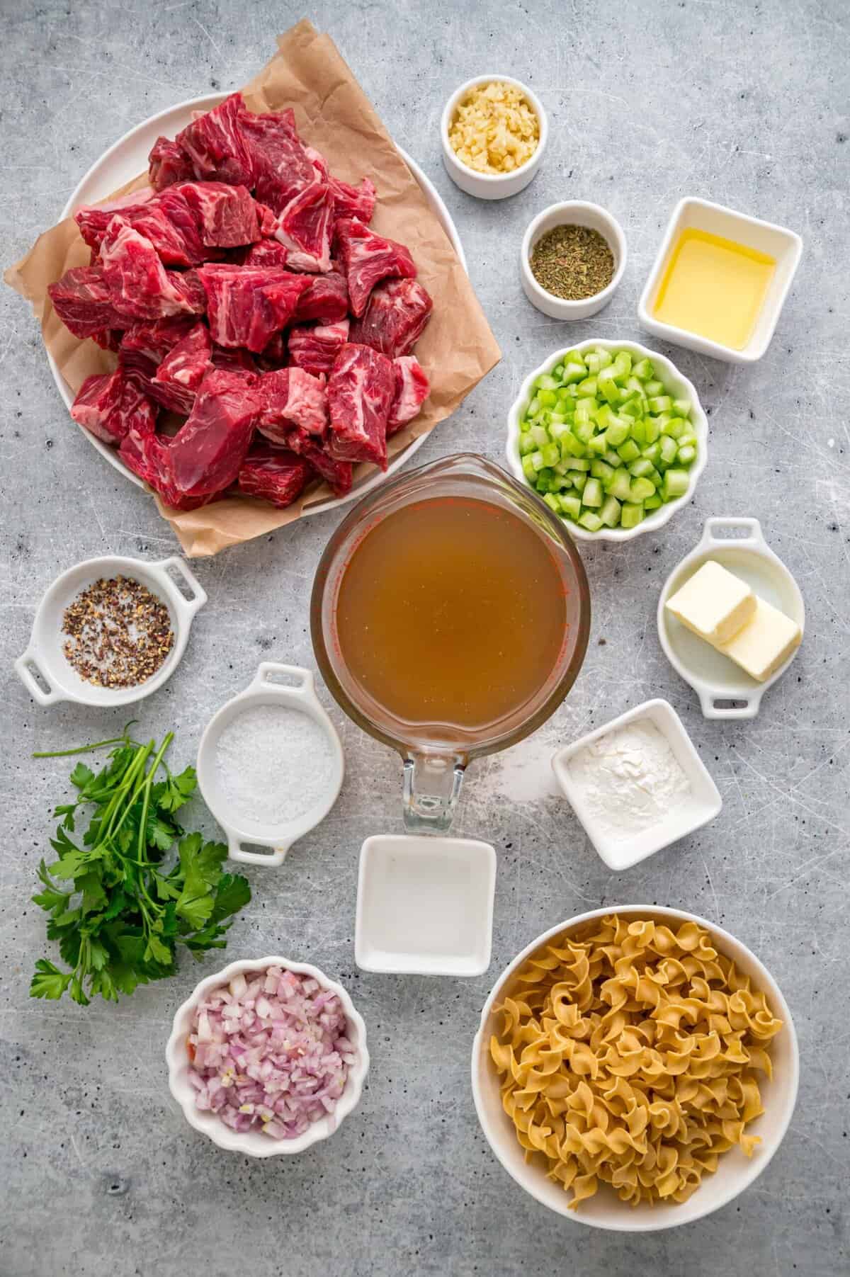 Tender chunks of beef are cooked in a rich, savory gravy and served over egg noodles in this easy Beef and Noodles recipe. Overhead view of ingredients needed to make beef and noodles