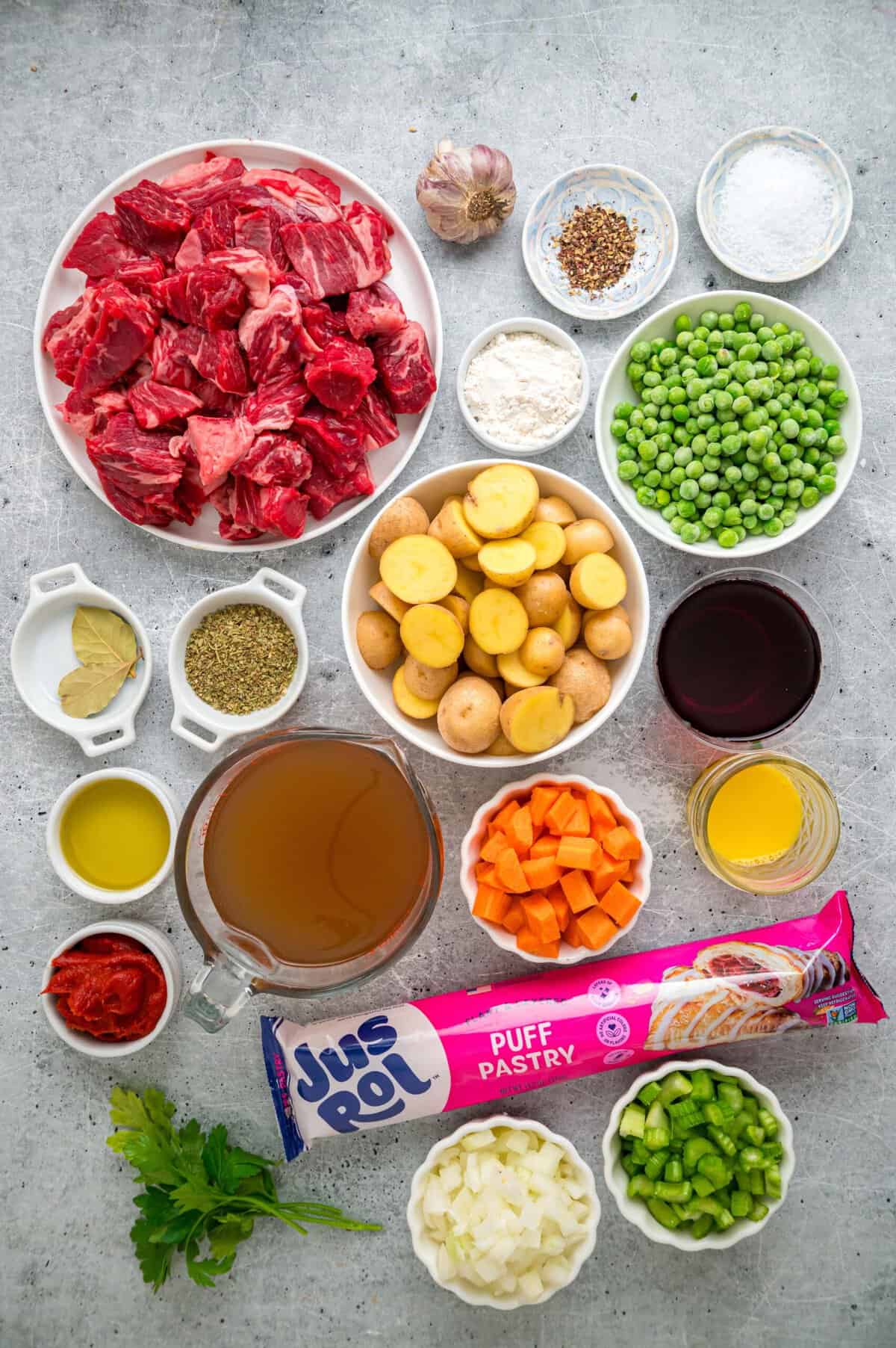 A rich, savory stew filled with tender chunks of beef and veggies is topped with a flaky, buttery puff pastry in this Beef Pot Pie recipe. Overhead view of ingredients needed to make beef pot pie