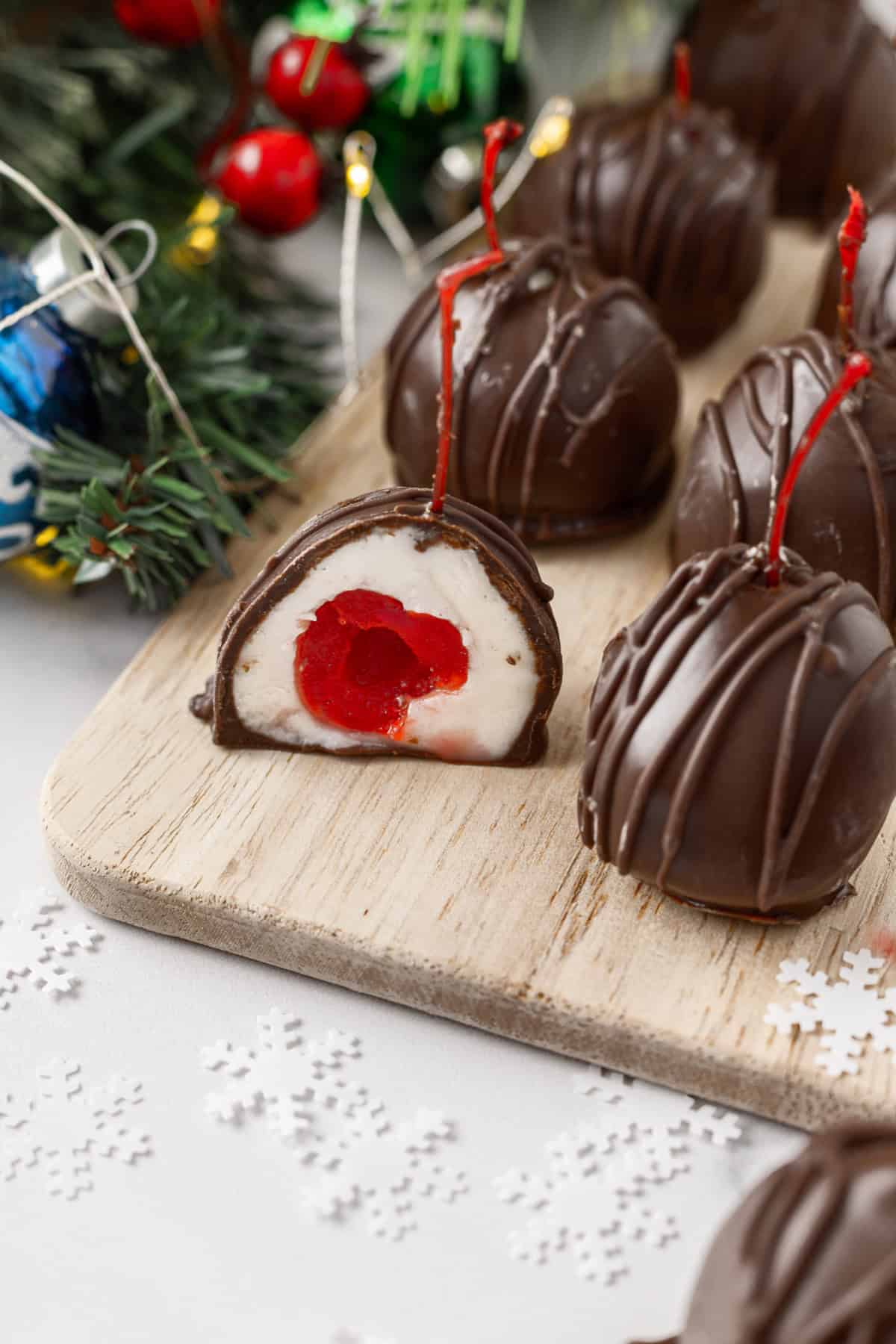 These classic Chocolate Covered Cherries are incredibly easy to make, and always a favorite for Christmas, Valentine's Day, or any time of year. Chocolate Covered Cherries on a board with a Holiday setting