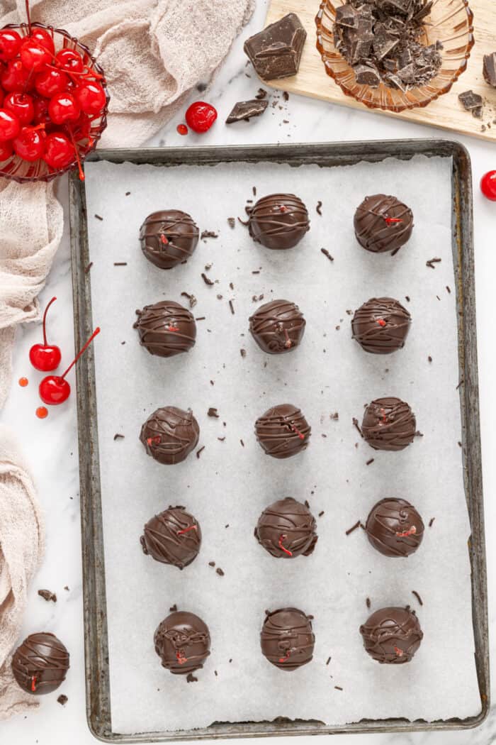 These classic Chocolate Covered Cherries are incredibly easy to make, and always a favorite for Christmas, Valentine's Day, or any time of year. chocolate covered cherries on a baking sheet