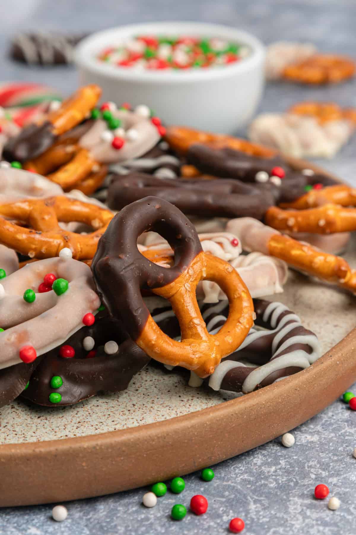 These Chocolate Covered Pretzels are made with pretzel twists coated in dark and white chocolate and decorated with sprinkles. Chocolate Covered Pretzels on a plate