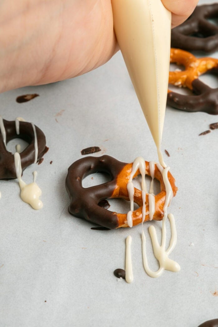 These Chocolate Covered Pretzels are made with pretzel twists coated in dark and white chocolate and decorated with sprinkles. decorating pretzels with chocolate