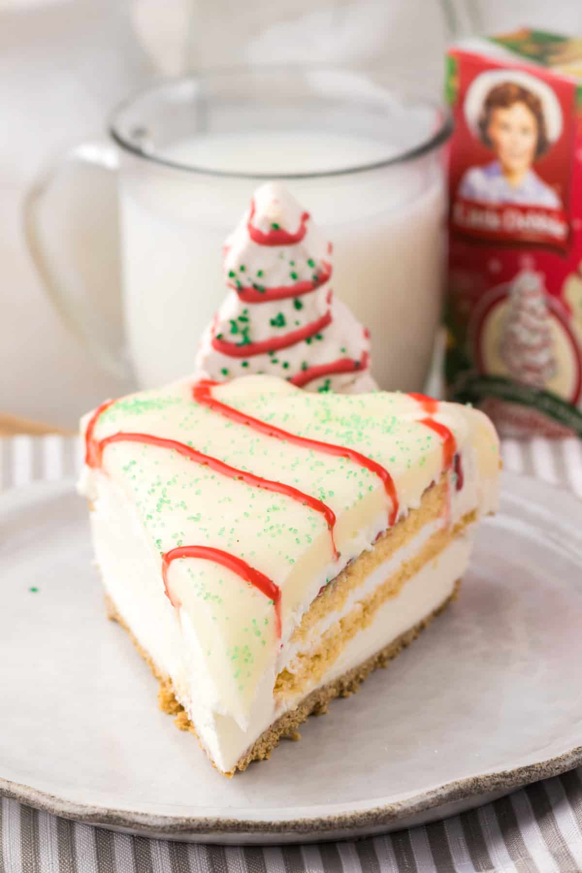 With no baking required, this Little Debbie Christmas Tree Cheesecake is a fun, festive, and nostalgic Christmas treat. No Bake Little Debbie Christmas Tree Cheesecake slice on a plate