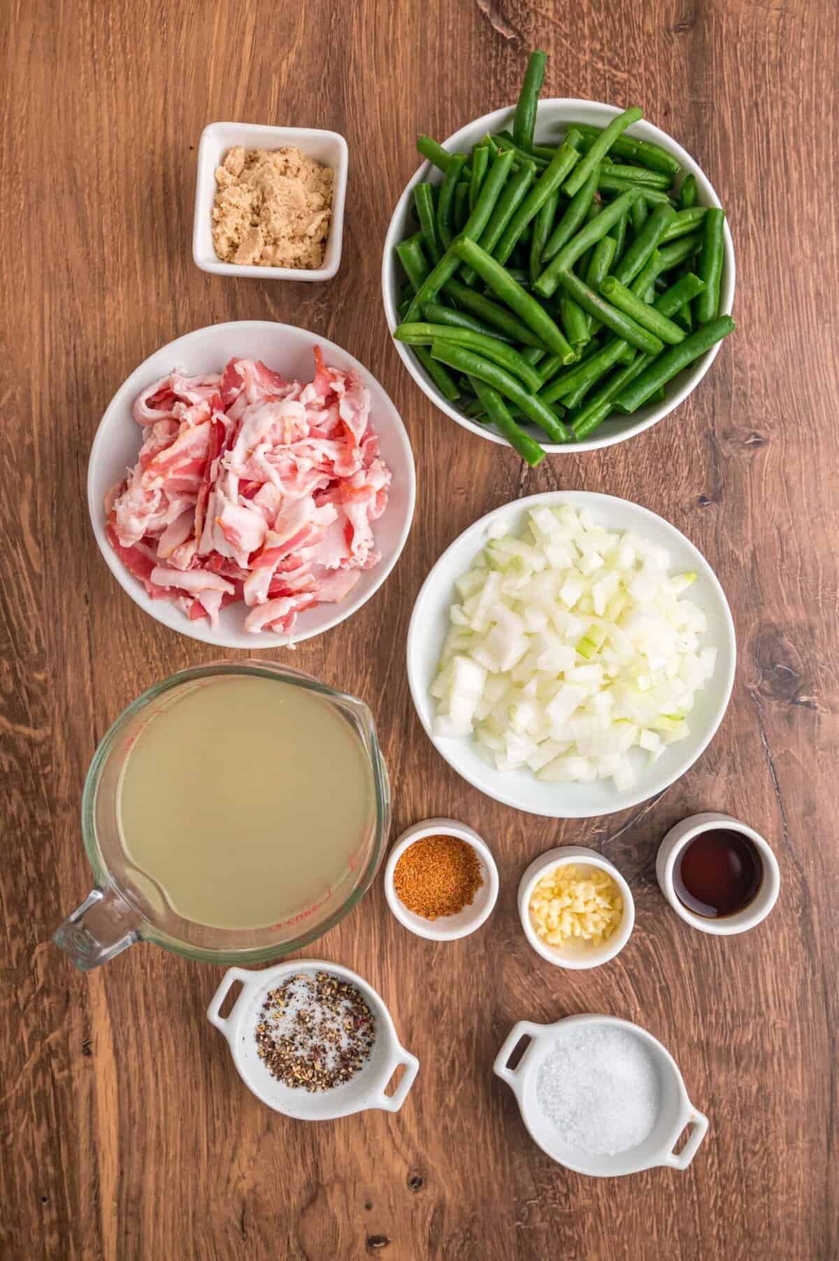 Fresh green beans are slow-cooked until tender with garlic, onion, bacon, and some Cajun seasoning in this Southern Green Beans recipe. Overhead view of ingredients needed to make Southern green beans