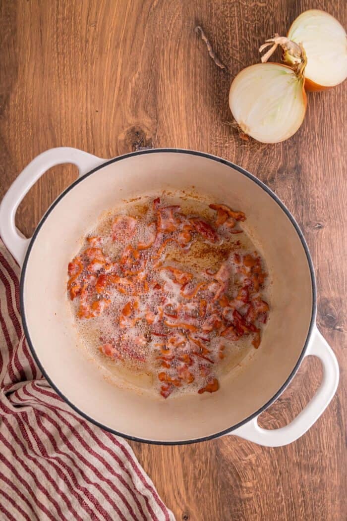 Fresh green beans are slow-cooked until tender with garlic, onion, bacon, and some Cajun seasoning in this Southern Green Beans recipe. Chopped bacon cooking in a pot