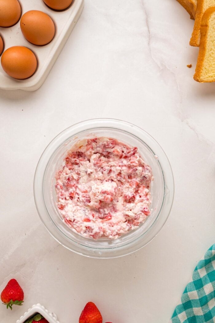 This Cream Cheese Stuffed French Toast recipe is an easy, decadent way to elevate basic French toast. Perfect for weekend brunch! Cream cheese, sugar, and strawberries in a bowl