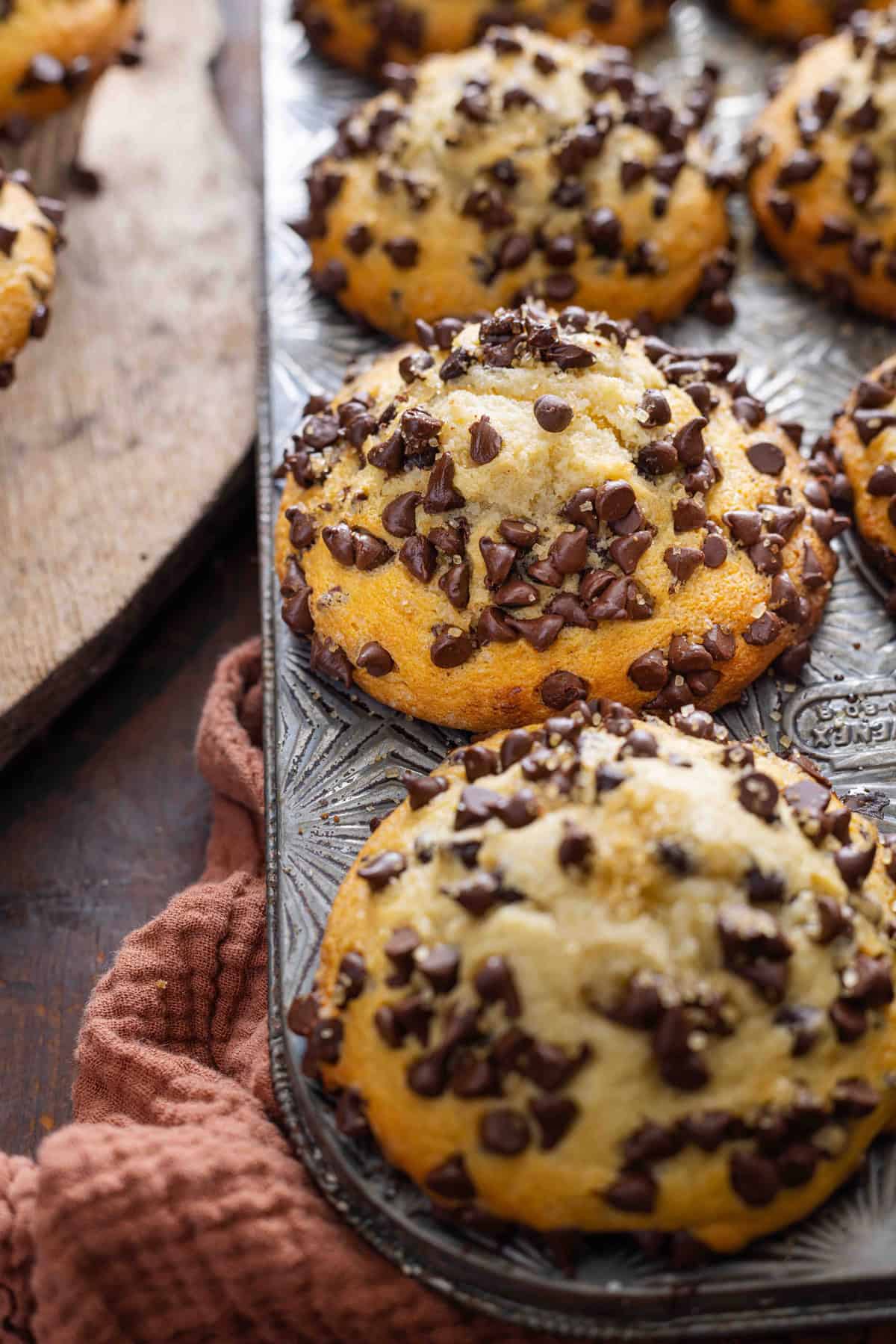 Chocolate chip muffins with tall domes in a muffin pan