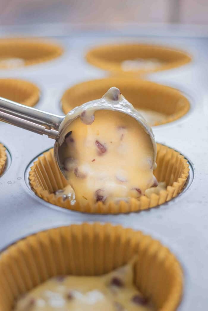 Using a cookie scoop to fill muffin liners