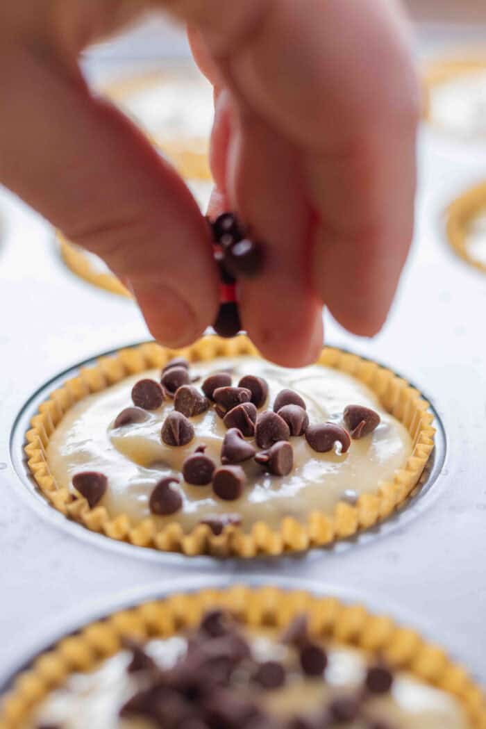 Sprinkling mini chocolate chips on top of muffin batter