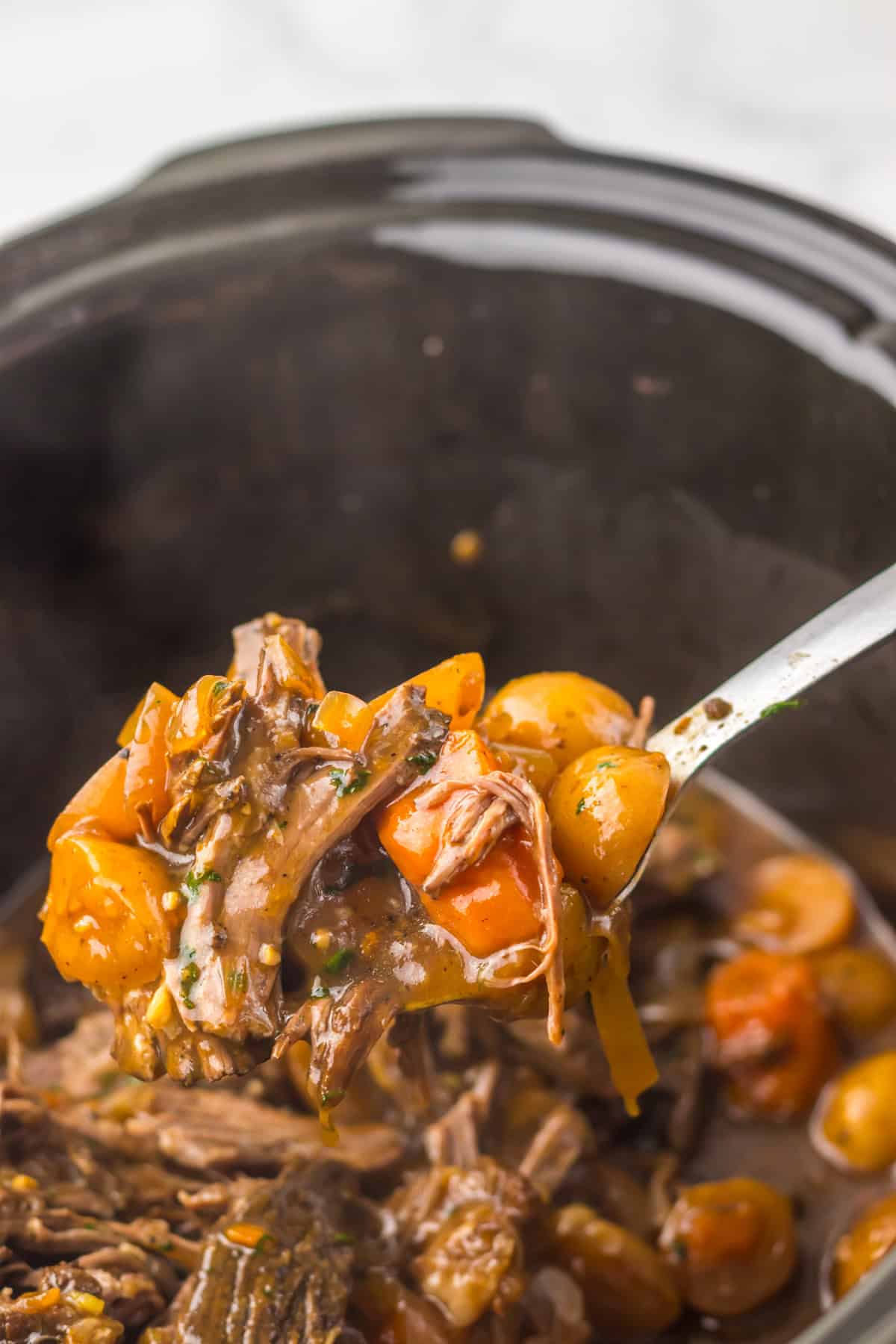 This Slow Cooker Coca Cola Pot Roast is the ultimate hearty, comforting dinner that practically makes itself. A ladle of Coca Cola pot roast over a slow cooker