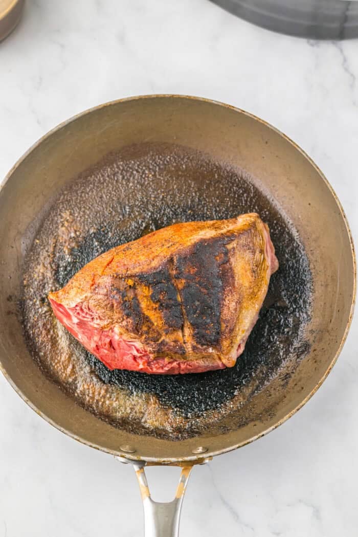 This Slow Cooker Coca Cola Pot Roast is the ultimate hearty, comforting dinner that practically makes itself. A chuck roast searing in a pan