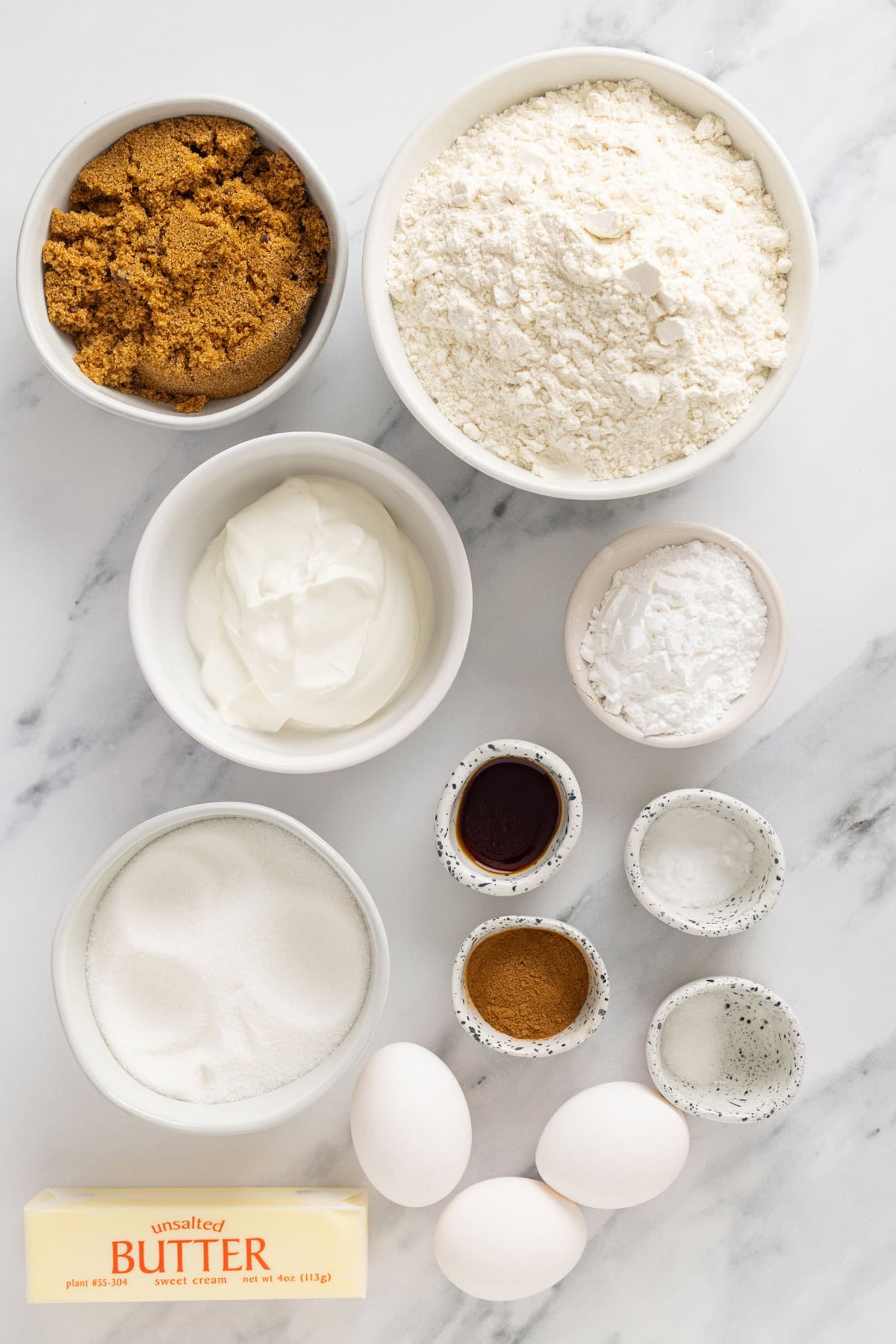 Tender, moist cake is topped with a thick layer of cinnamon crumb topping in this Easy Crumb Cake Recipe. Enjoy with a cup of coffee. Overhead view of ingredients needed to make crumb cake