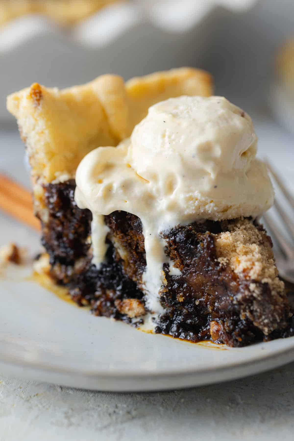 A slice of shoo fly pie topped with ice cream