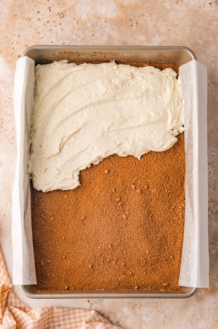 This Sour Cream Coffee Cake is soft and buttery with a generous cinnamon sugar ribbon baked through the middle & streusel topping. Spreading coffee cake batter on top of cinnamon sugar
