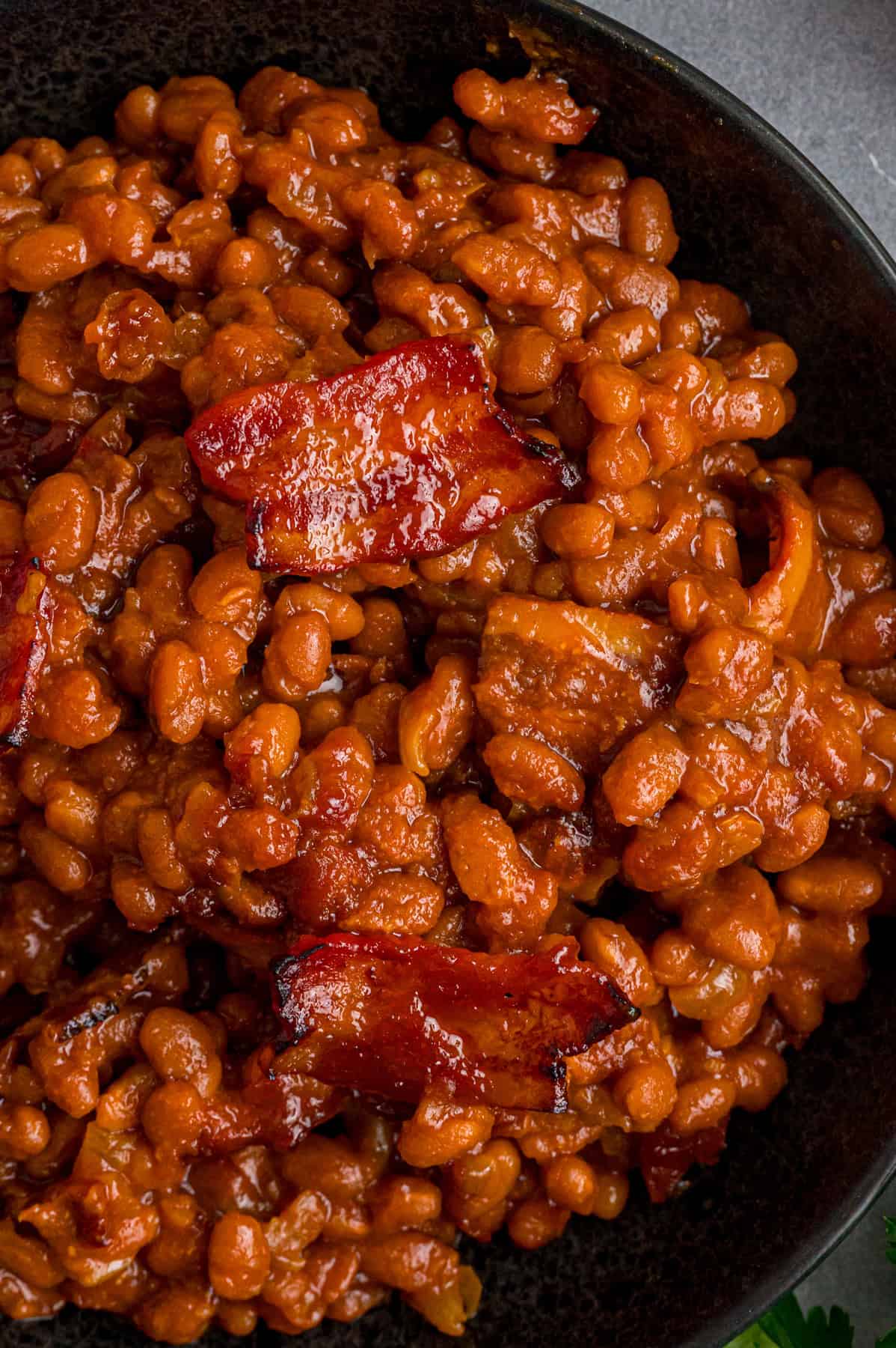 This easy Baked Beans recipe begins with pork and beans to keep things simple and salty bacon to add a final touch. Great for BBQs! A plate of homemade baked beans