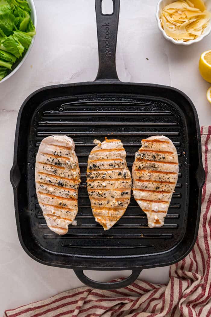 Crunchy seasoned croutons, creamy homemade dressing, and grilled strips of chicken make this Chicken Caesar Salad an easy dinner. Chicken cutlets on a grill pan