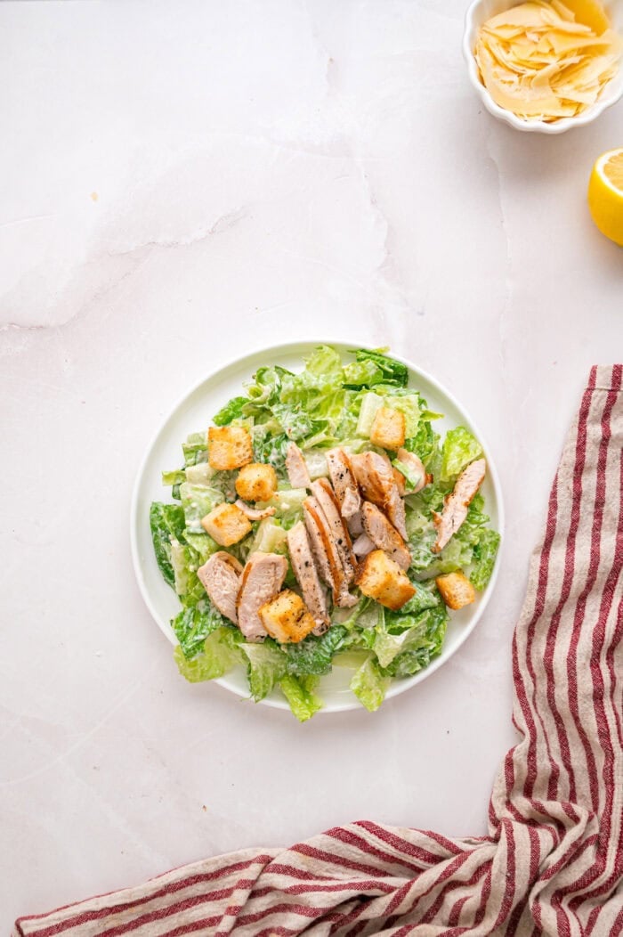 Crunchy seasoned croutons, creamy homemade dressing, and grilled strips of chicken make this Chicken Caesar Salad an easy dinner. Overhead view of a plate of chicken caesar salad