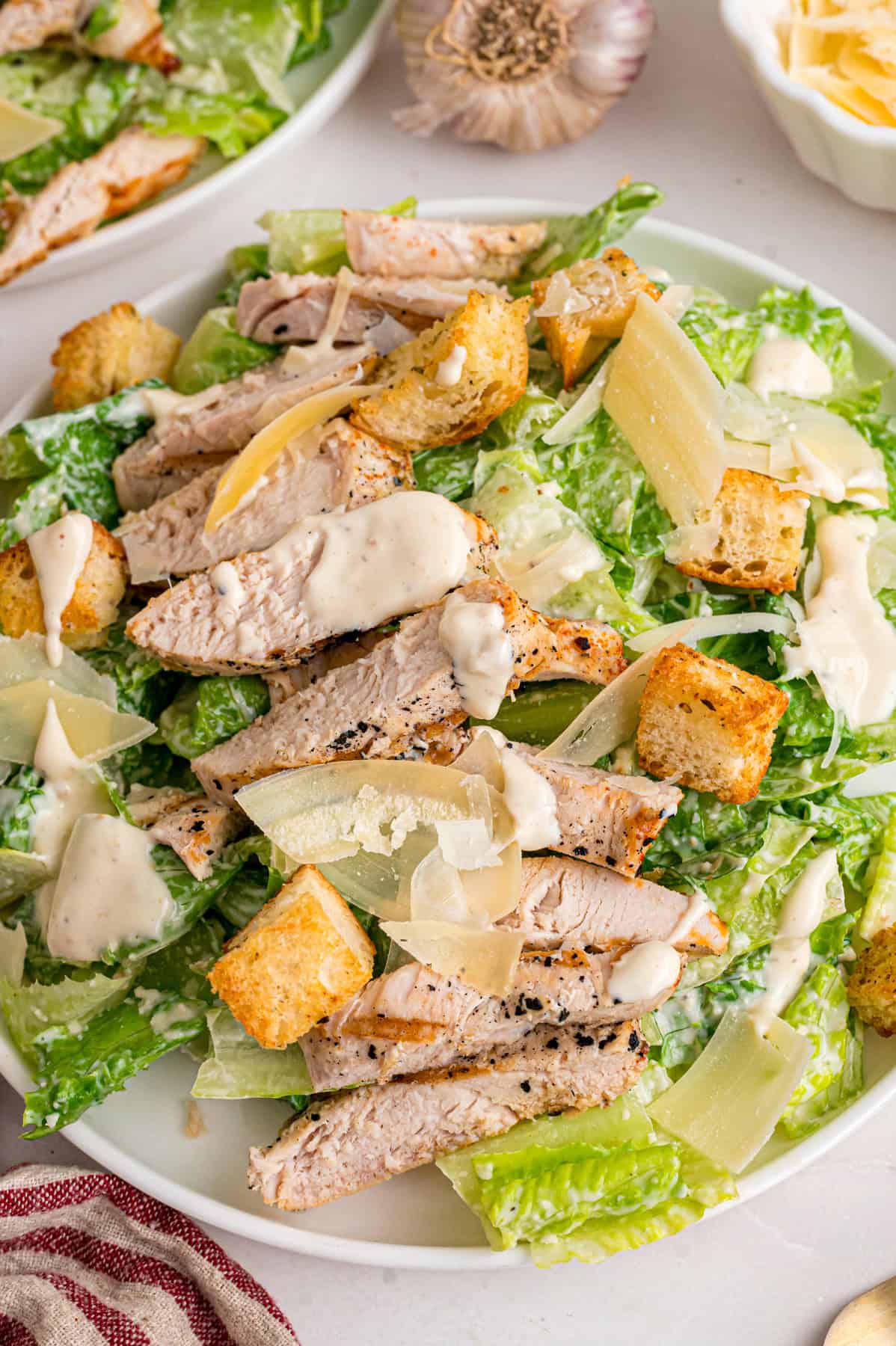 Crunchy seasoned croutons, creamy homemade dressing, and grilled strips of chicken make this Chicken Caesar Salad an easy dinner. Close up of a plate of chicken caesar salad