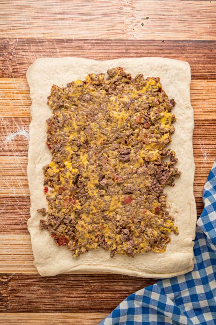 Cheesy ground beef mixture spread on pizza dough