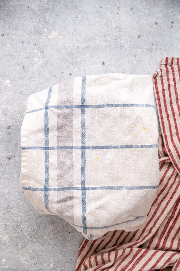 This Hawaiian Rolls recipe makes soft, fluffy rolls that taste just like the store-bought version – maybe even better. A warm towel covering a glass bowl