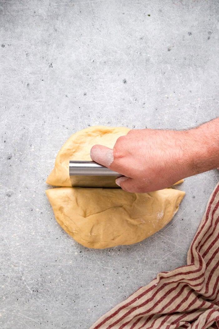 This Hawaiian Rolls recipe makes soft, fluffy rolls that taste just like the store-bought version – maybe even better. Using a cutter to slice dough into pieces for a Hawaiian rolls recipe