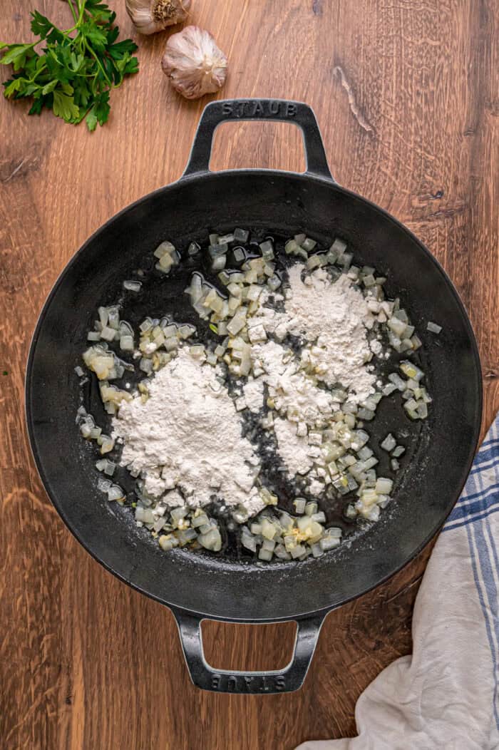 A creamy mixture of veggies and chicken is topped with a flaky, buttery topping in this Puff Pastry Chicken Pot Pie Recipe. Sauteed onion and garlic in a pot with flour