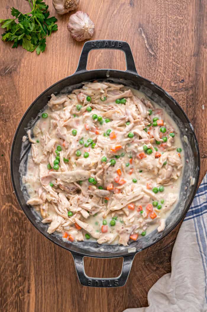 A creamy mixture of veggies and chicken is topped with a flaky, buttery topping in this Puff Pastry Chicken Pot Pie Recipe. Chicken pot pie filling in a pot