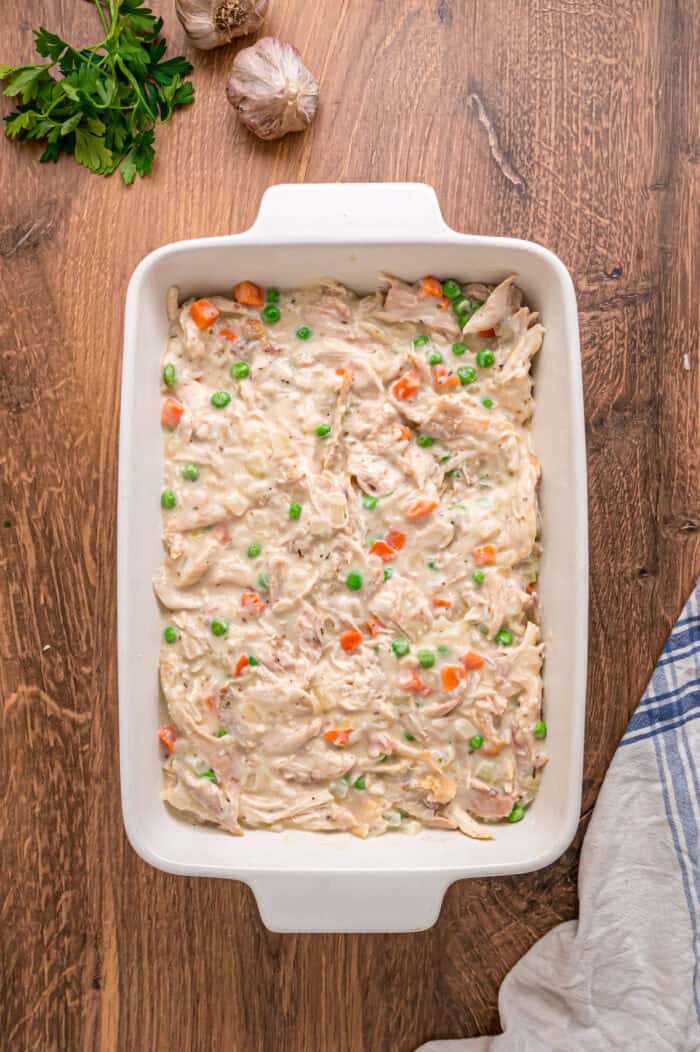 A creamy mixture of veggies and chicken is topped with a flaky, buttery topping in this Puff Pastry Chicken Pot Pie Recipe. Chicken pot pie filling in a baking dish