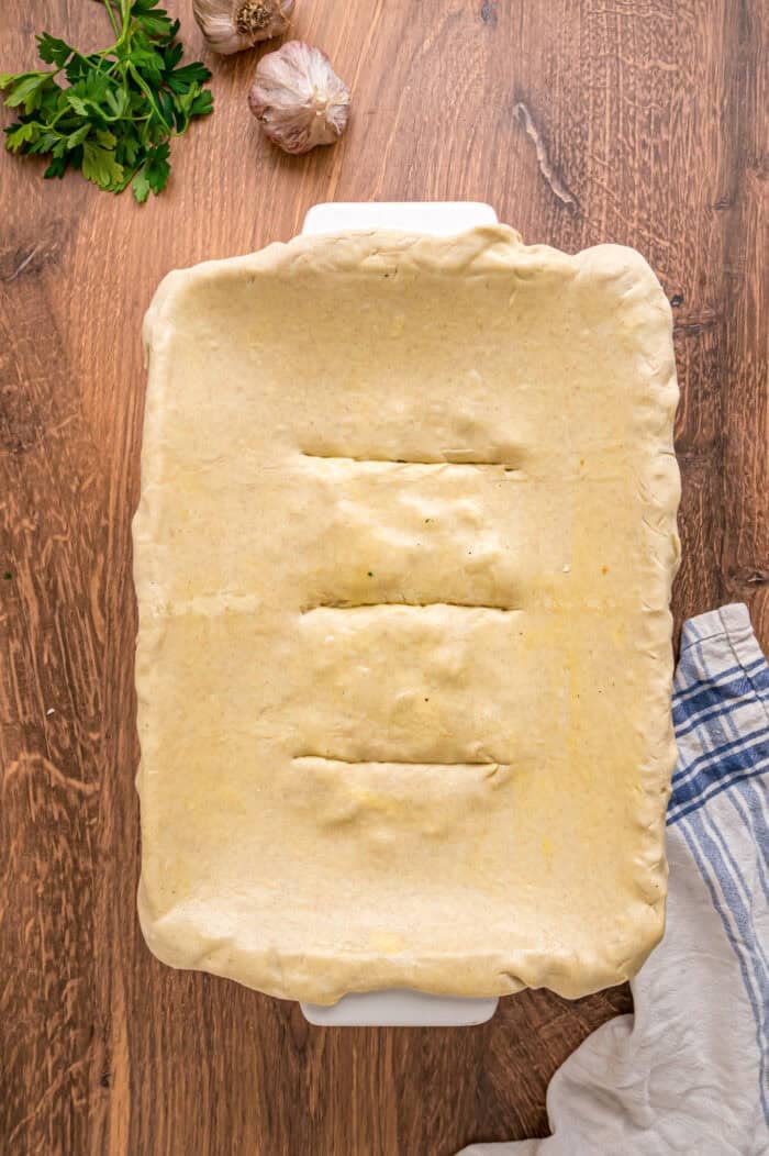 A creamy mixture of veggies and chicken is topped with a flaky, buttery topping in this Puff Pastry Chicken Pot Pie Recipe. Puff pastry on a baking dish with slits cut in the center