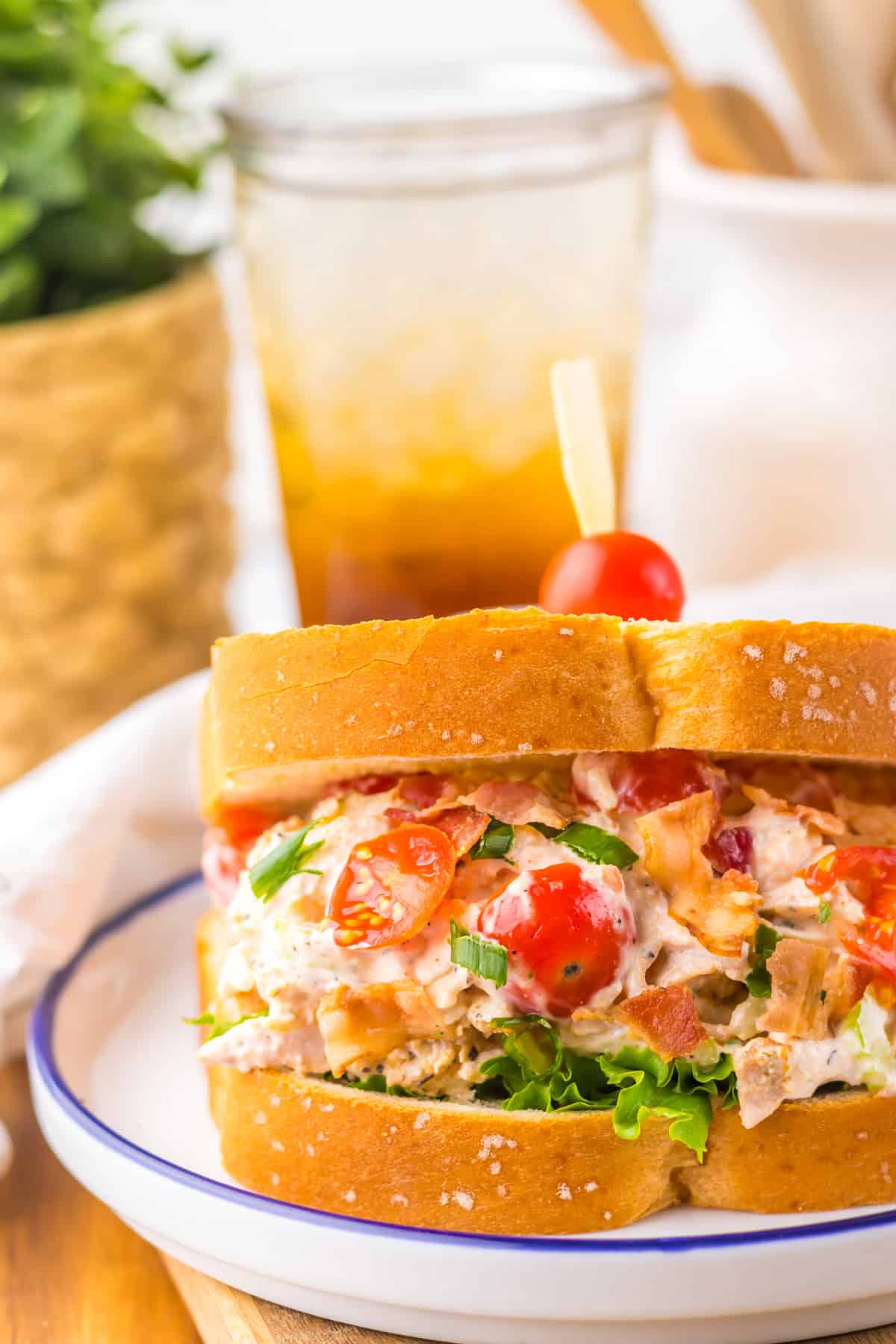 Full of tender chicken, crispy bacon, and tomatoes tossed in a creamy dressing, this BLT Chicken Salad is ready in just 5 minutes. A BLT chicken salad sandwich in front of an iced tea