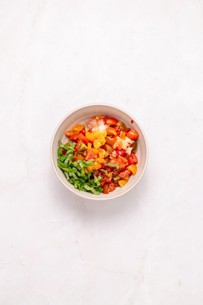 Diced tomatoes, basil, and garlic in a bowl