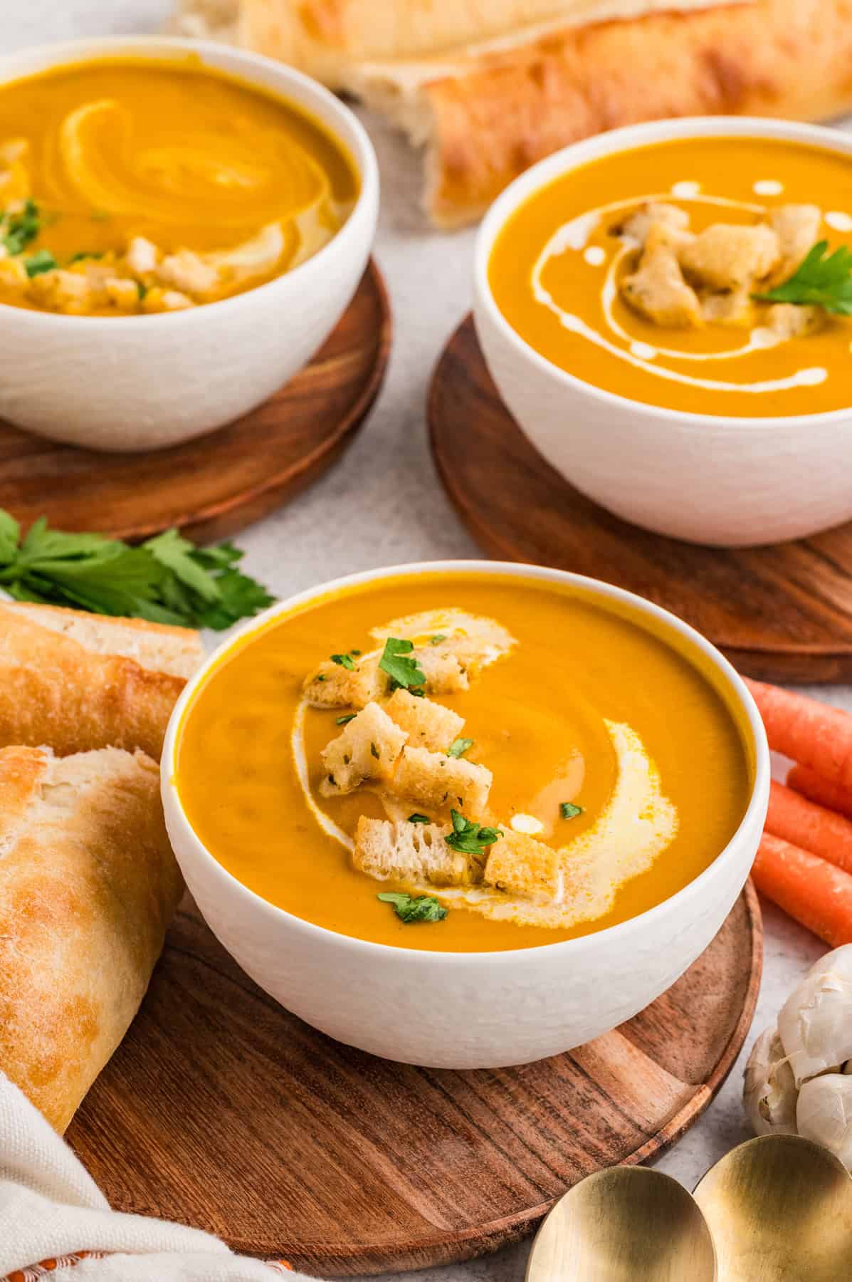 With caramelized carrots, onion, and garlic, this Roasted Carrot Soup is ready in 45 minutes. Gluten-free & vegetarian! Three bowls of carrot soup