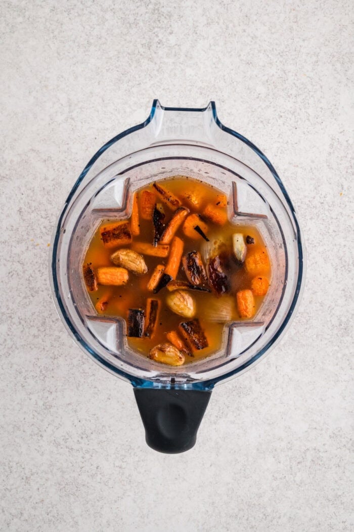 With caramelized carrots, onion, and garlic, this Roasted Carrot Soup is ready in 45 minutes. Gluten-free & vegetarian! Roasted carrots, onion, and garlic in a blender with broth