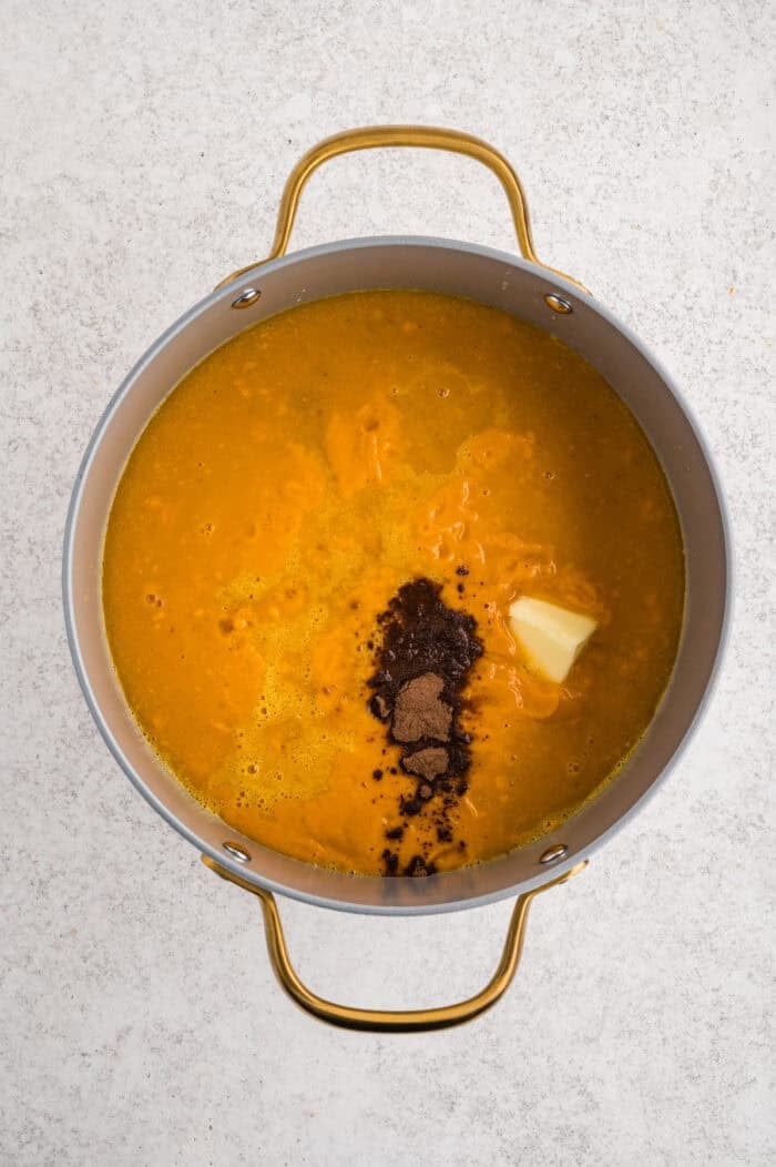 With caramelized carrots, onion, and garlic, this Roasted Carrot Soup is ready in 45 minutes. Gluten-free & vegetarian! Spices and butter added to a pot of carrot soup