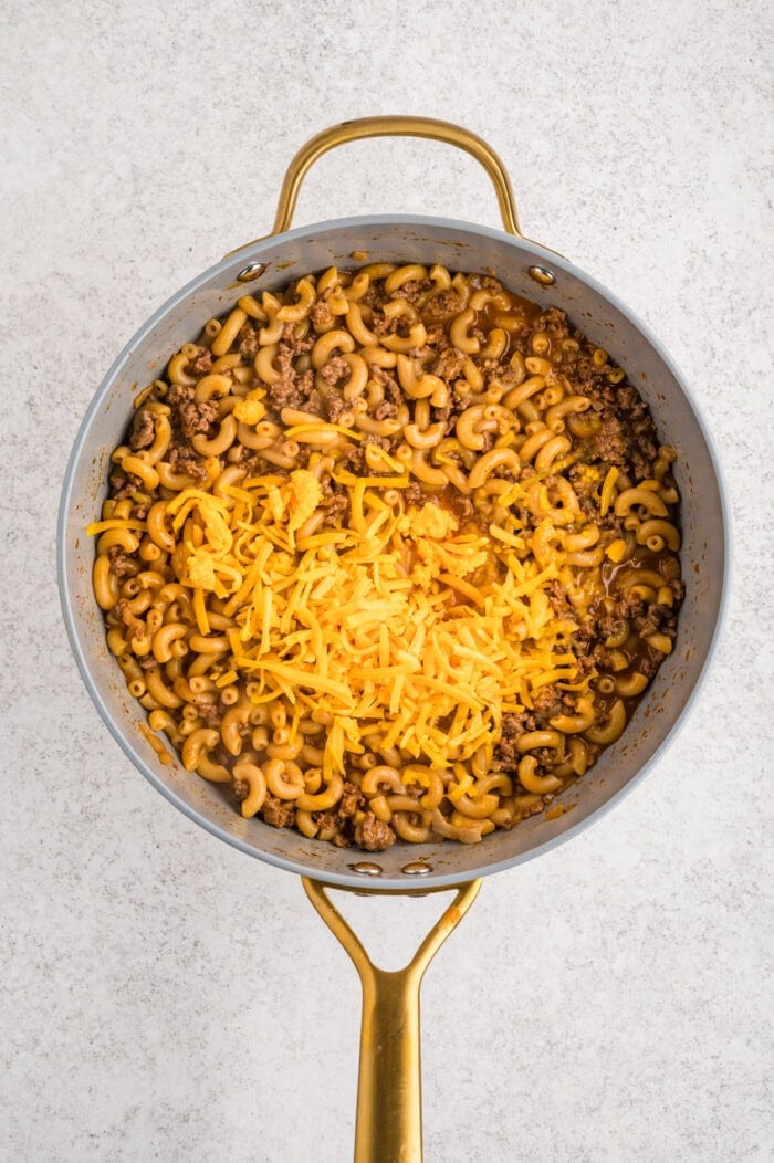 Cheddar cheese added to cooked macaroni noodles and ground beef
