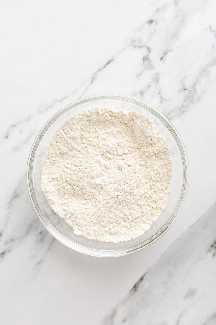 Chocolate and vanilla cake batter are swirled together, baked, and then layered with chocolate buttercream to create this Marble Cake recipe. Dry cake ingredients in a bowl