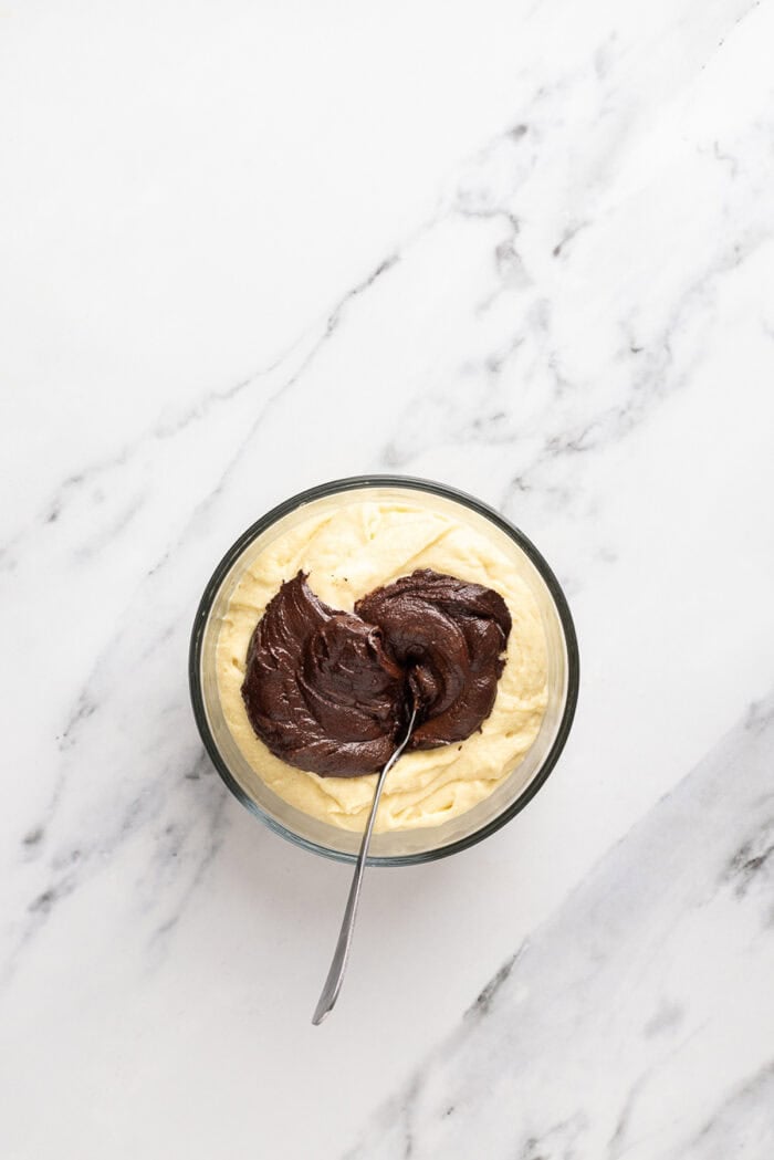 Chocolate and vanilla cake batter are swirled together, baked, and then layered with chocolate buttercream to create this Marble Cake recipe. Adding melted chocolate to vanilla cake batter