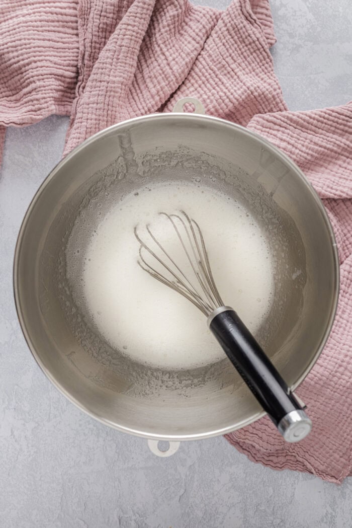 Light and fluffy just like a marshmallow, this Marshmallow Frosting recipe takes just 5 ingredients and 10 minutes to prepare. Whisking frothy egg whites in a metal bowl