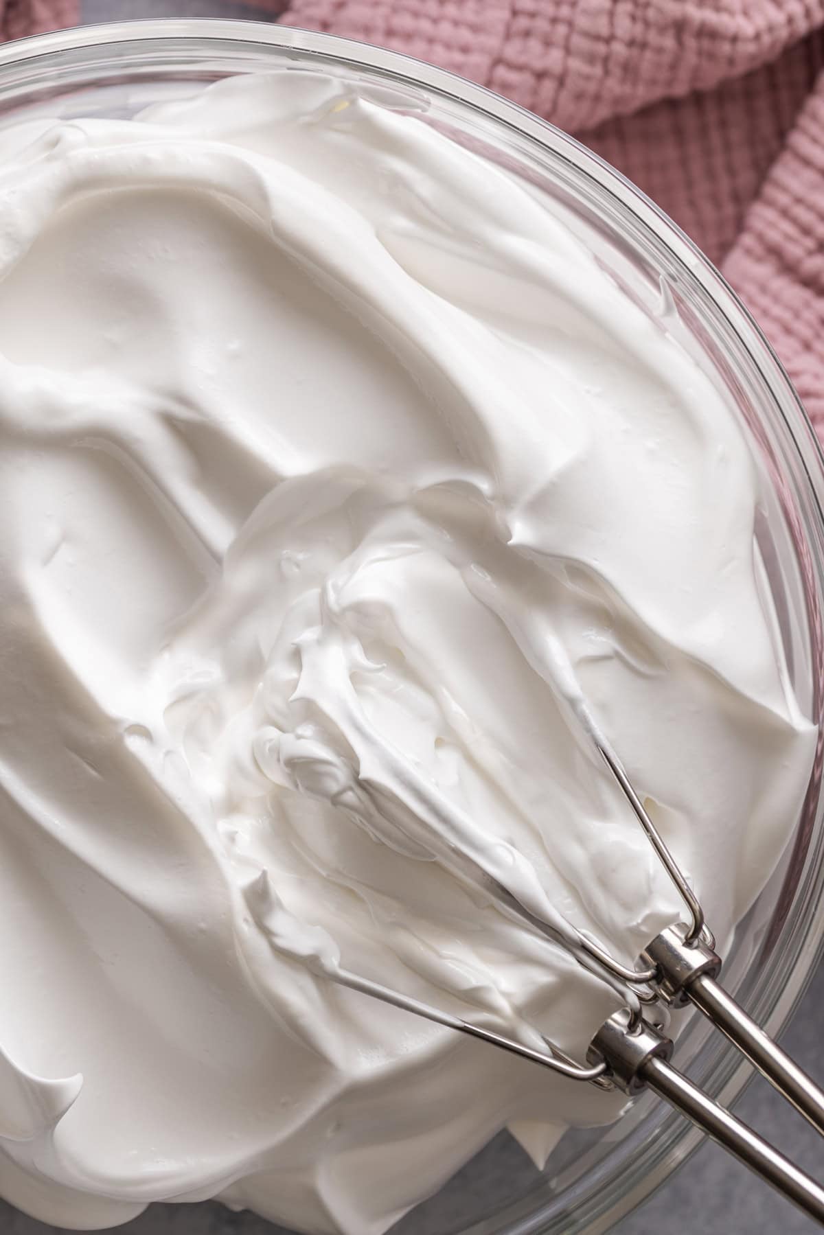 Light and fluffy just like a marshmallow, this Marshmallow Frosting recipe takes just 5 ingredients and 10 minutes to prepare. A whisk in a bowl of marshmallow frosting